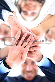 Small group of business people joining hands, low angle view