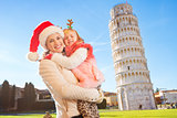 Happy mother in Christmas hat with daughter in Pisa, Italy