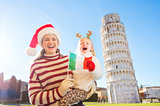 Mother in Christmas hat and daughter holding Italian flag. Pisa