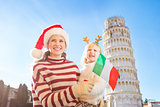 Mother and daughter holding Italian flag. Christmas in Pisa