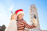 Mother and daughter taking selfies. Christmas in Pisa