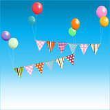 Bunting floating with balloons over blue sky