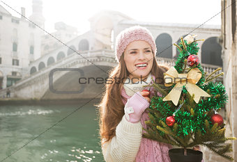 Woman with Christmas tree in Venice looking into distance