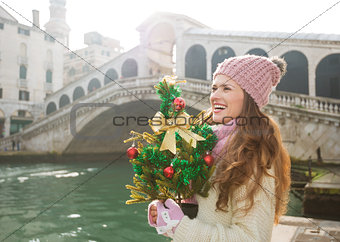 Woman with Christmas tree in Venice looking into distance