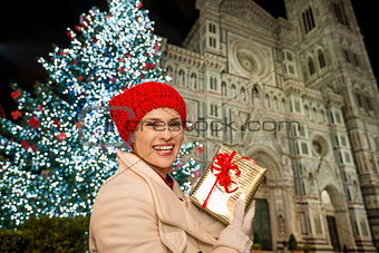 Marry woman with gift box near Christmas tree in Florence, Italy