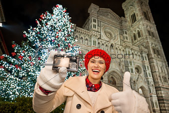 Woman showing camera and thumbs up in Christmas Florence, Italy