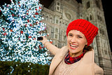 Happy woman taking photos of Christmas tree in Florence, Italy