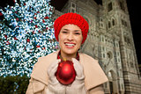 Young woman holding Christmas ball near Duomo in Florence, Italy