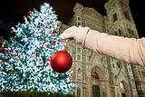 Closeup on hand pretend decorating Christmas tree in Florence