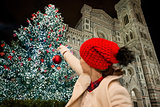 Woman pretend decorating Christmas tree in Florence, Italy