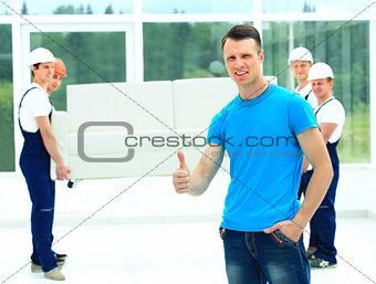 happy male movers in uniform carrying white sofa