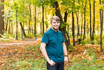 Young smiling man portrait laying in  autumn park.