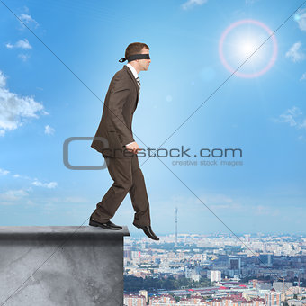 Businessman walking from edge of building roof