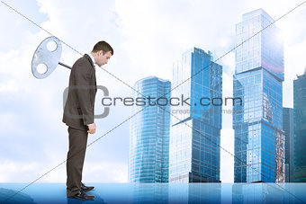 Businessman with key in back and city scape