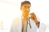 Asian Indian medical doctor holding stethoscope 