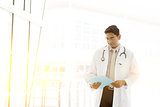 Asian Indian medical doctor reading medical report