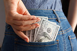Woman hand pick pack of 100 dollar banknotes from pocket