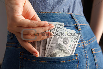 Woman hand pick pack of 100 dollar banknotes from pocket