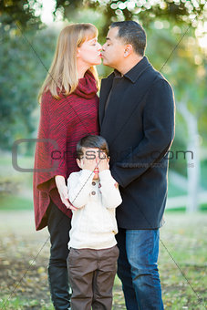 Mix Race Couple Kissing As Young Son Hides His Eyes