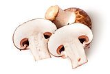 Whole and two half brown champignons