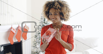 Smiling African woman holding a Christmas gift
