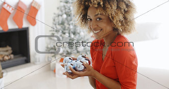 Young woman carrying a handful of Xmas decorations