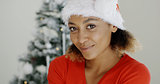 Smiling woman in a festive red Santa hat