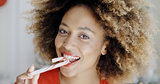 Young woman biting a festive candy cane