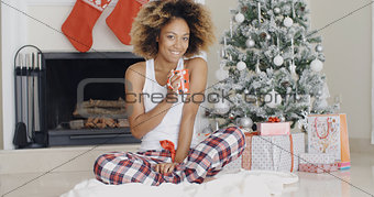 Smiling young woman enjoying a cup of Xmas coffee