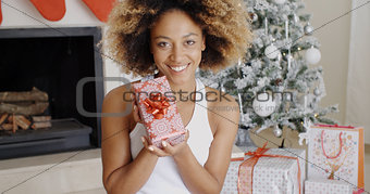 Pretty smiling woman displaying a Christmas gift