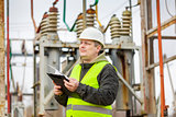 Electrical Engineer with folder in electrical substation