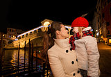 Happy mother and daughter near Rialto Bridge in Christmas Venice