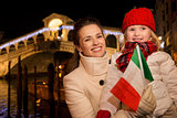 Mother and daughter with Italian flag in Christmas Venice, Italy
