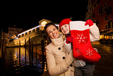 Happy mother and daughter showing Christmas sock in Venice