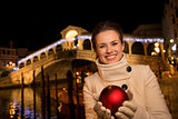 Happy woman with Christmas Ball near Rialto Bridge in Venice