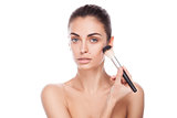 Portrait of woman with makeup brush near her face