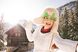 Woman in a Christmas glasses taking selfie near a mountain house