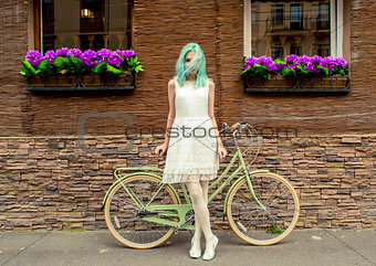 Young girl standing near a bicycle