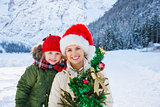 Happy mother and child with Christmas tree in front of mountains