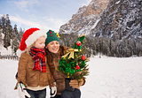 Mother and child looking on Christmas tree in front of mountains