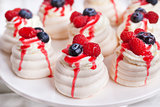 Pavlova meringue cakes decorated with fresh berries