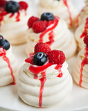 Pavlova meringue cakes decorated with fresh berries