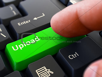 Pressing Green Button Upload on Black Keyboard.