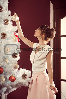 lovely female decorating christmas tree