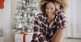 Happy young woman in front of a Christmas tree