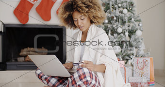 Pretty young woman buying Christmas gifts online