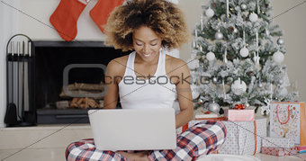 Woman using a laptop in front of the Xmas tree