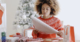 Happy young African woman wrapping presents