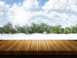 Wooden table with Christmas snowy landscape defocussed in the ba