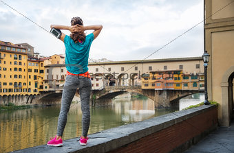Relaxed fitness woman standing in front of Ponte Vecchio